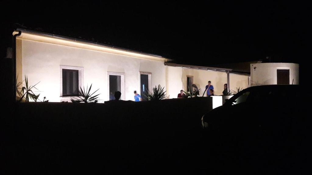 um grupo de pessoas em pé fora de uma casa à noite em Casa del nonnino em Chiaramonte Gulfi