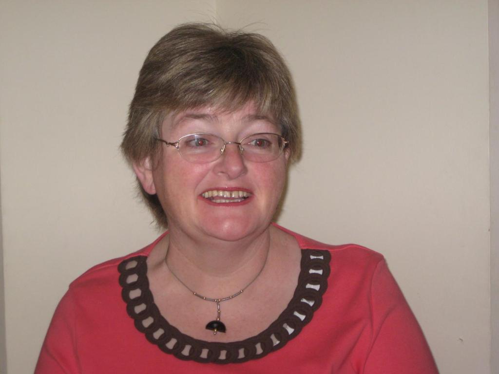 a woman wearing a red shirt and glasses at An Bruachan B&B in Kenmare