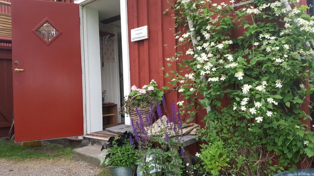 una casa roja con una puerta roja y flores en Rönnås en Tvååker