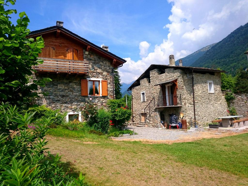 ein großes Steinhaus mit einem Holz in der Unterkunft Casa San Martino in Teglio