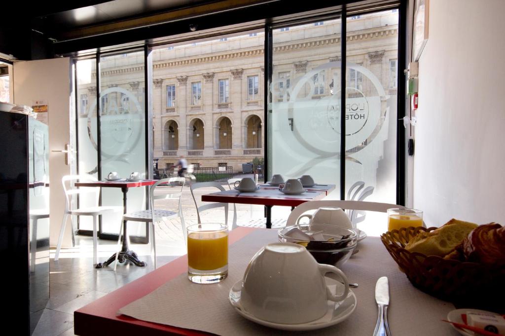 una mesa con tetera y un vaso de zumo de naranja en Hotel de L'Opéra en Burdeos