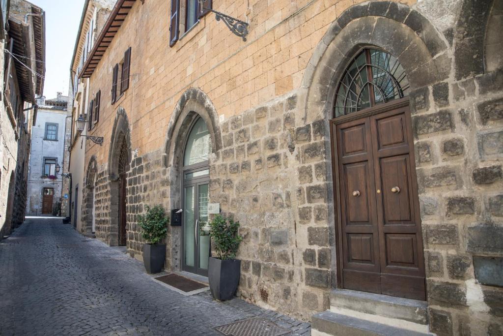 ein Backsteingebäude mit einer braunen Tür auf einer Straße in der Unterkunft La Luna Sopra Orvieto in Orvieto
