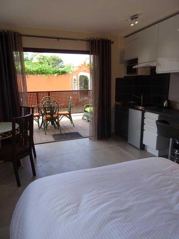 a bedroom with a bed and a kitchen and a patio at Les Terrasses in Lavérune