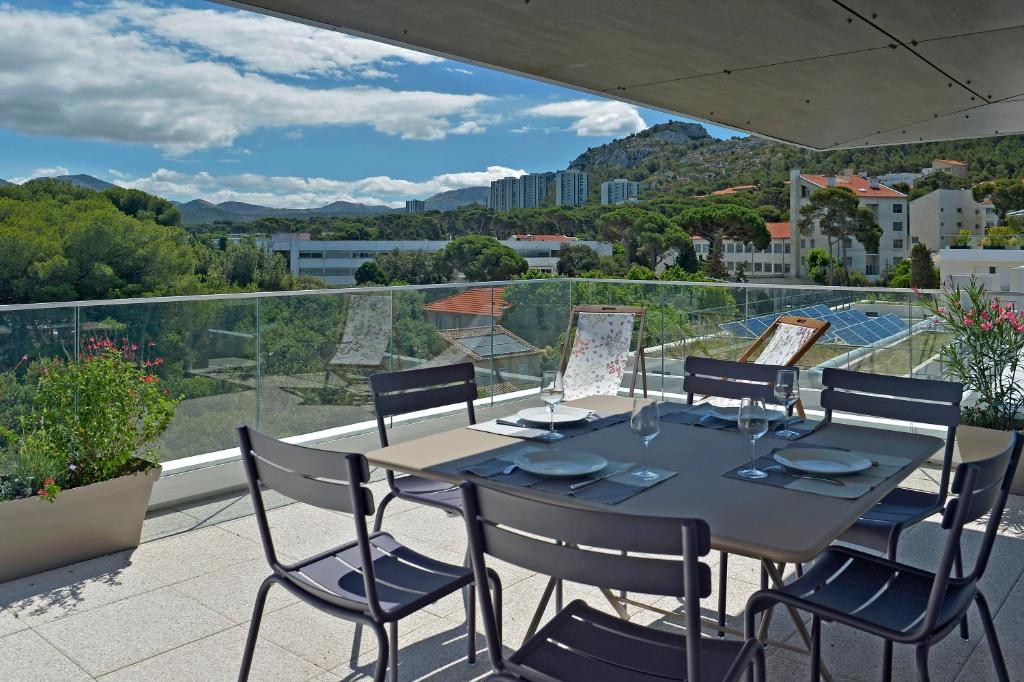 a table and chairs on a balcony with a view at Quintessens in Marseille