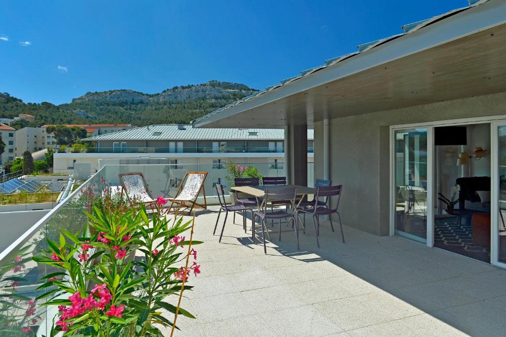 a patio with a table and chairs on a balcony at Quintessens in Marseille