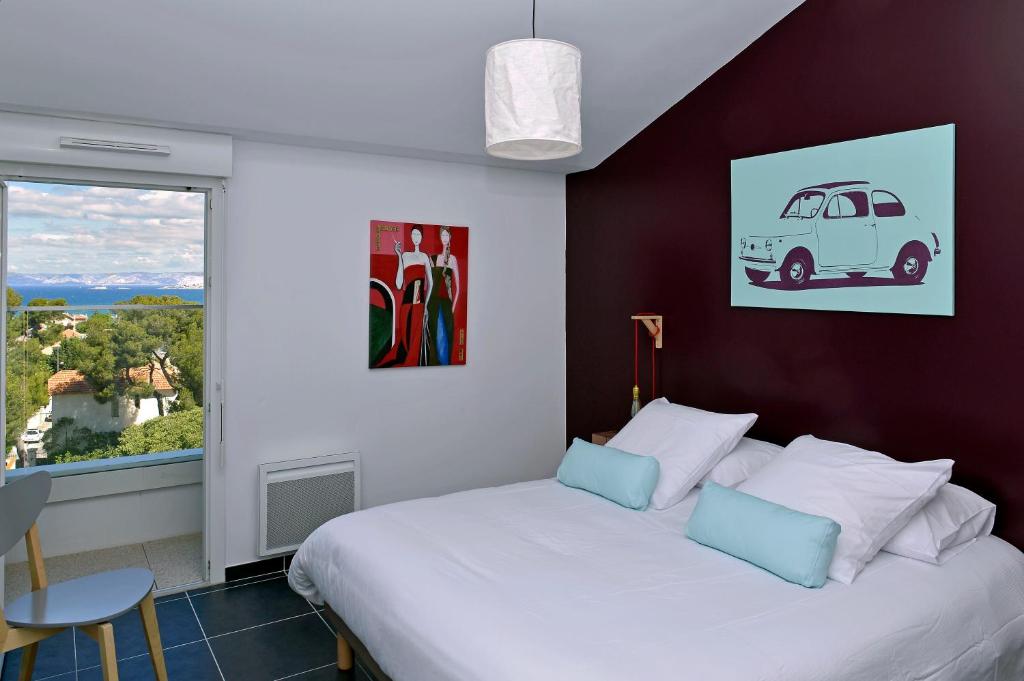 a bedroom with a white bed and a window at Quintessens in Marseille