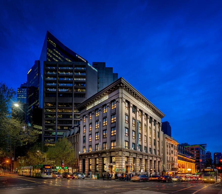 een groot gebouw in een stadsstraat 's nachts bij Batman's Hill on Collins in Melbourne