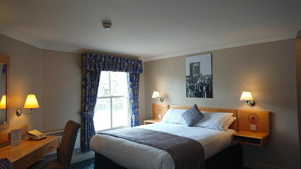 um quarto de hotel com uma cama e uma janela em The Queens Hotel em York