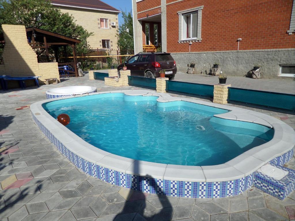ヴィチャゼヴォにあるDaniil Guest Houseの車を背景に庭に小さなプールがあります。