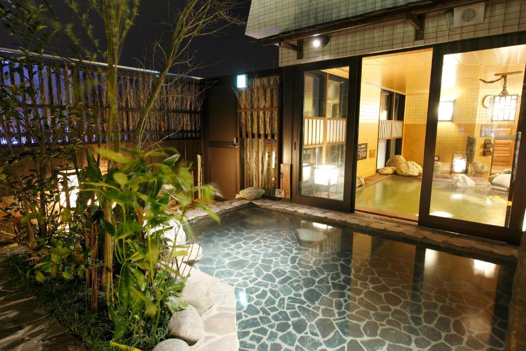 a swimming pool in the middle of a house at Dormy Inn Kagoshima in Kagoshima
