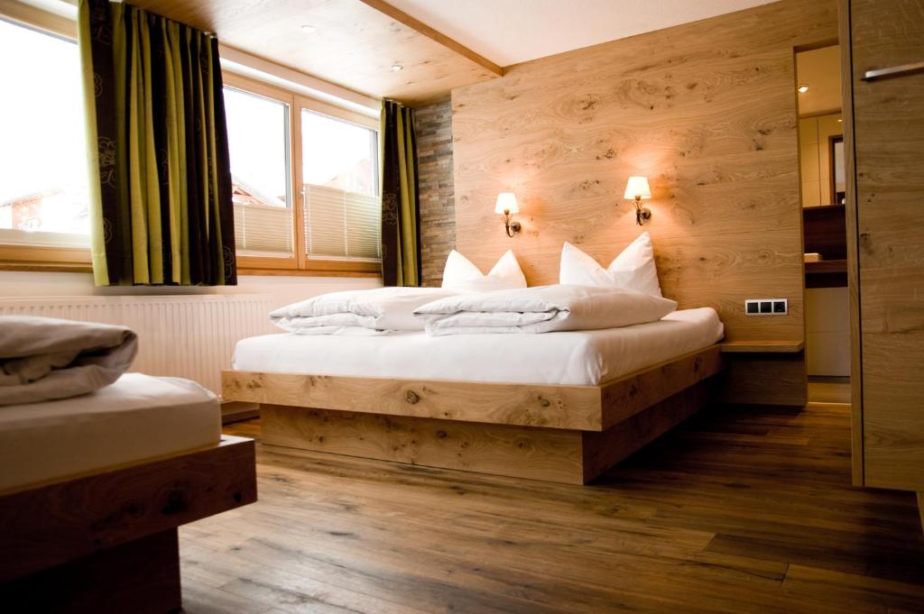 a bedroom with two beds and a large window at Haus Battisti in Sankt Anton am Arlberg