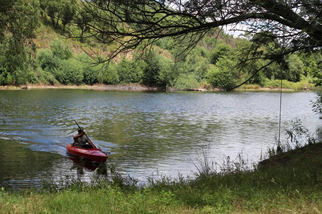 a person in a red boat on a lake at Quinta da Lontra in Tábua