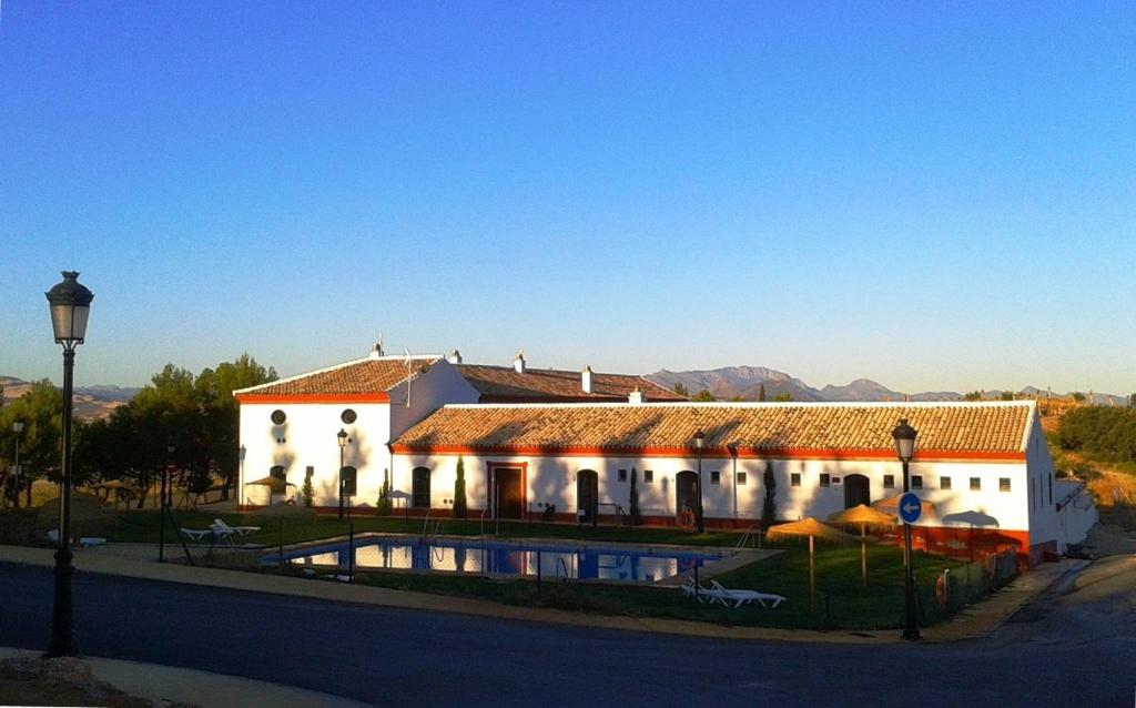 オルベラにあるComplejo Pueblo Blancoの白い大きな建物で、目の前にプールがあります。