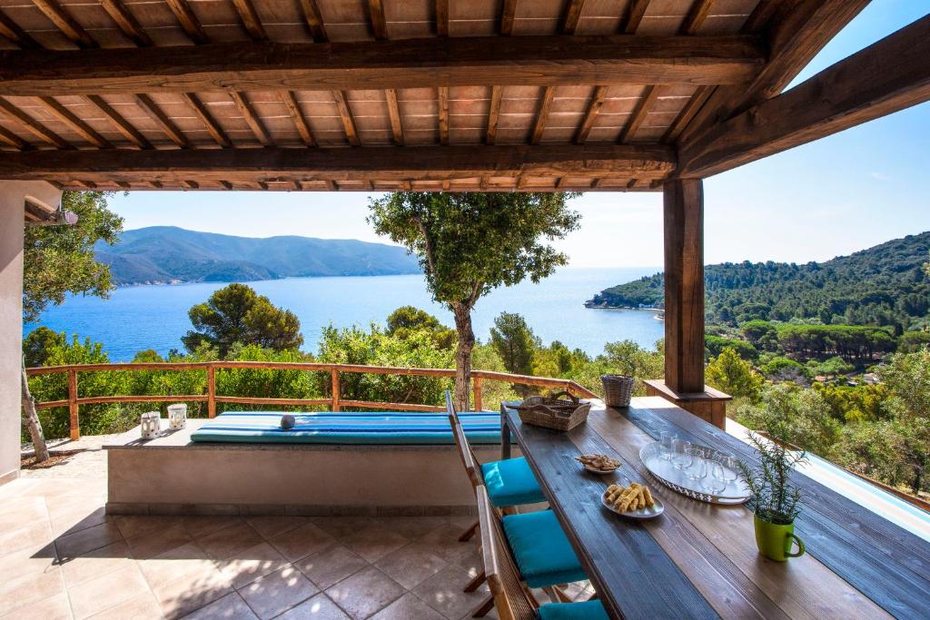 una terrazza all'aperto con piscina e vista sull'acqua di Agriturismo Galenzana a Marina di Campo