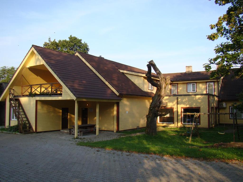 una casa grande con un árbol delante en Kõrtsitalu külalistemaja, en Kõpu