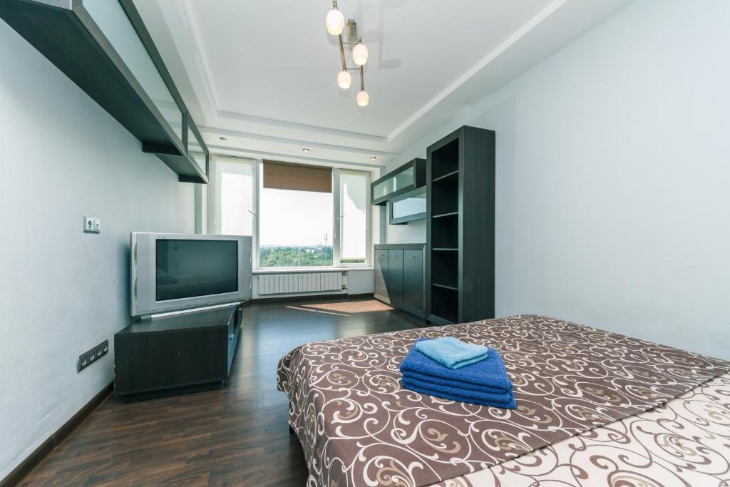a bedroom with a bed and a television in it at Apartments on Henerala Zhmachenka in Kyiv
