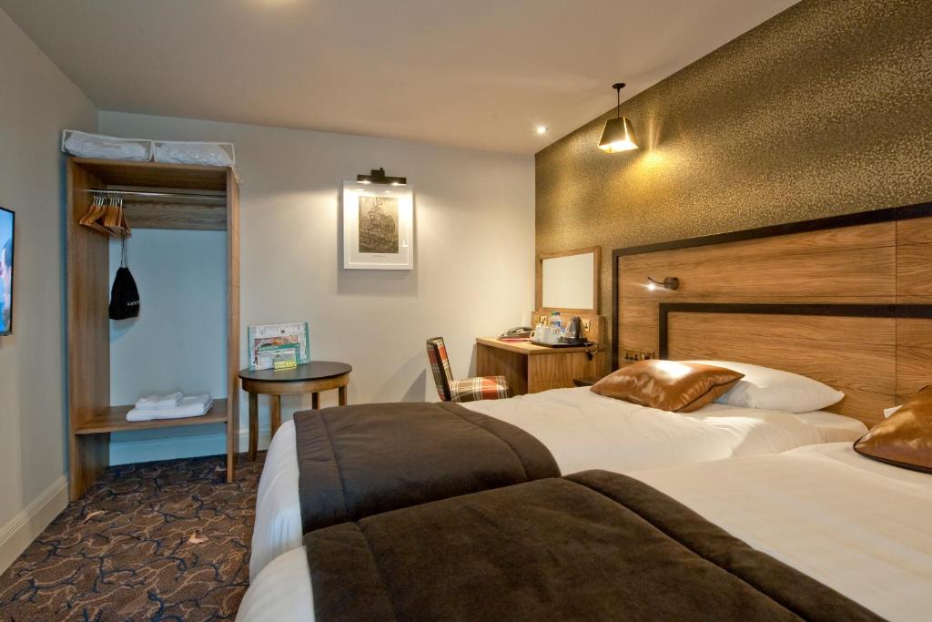 Habitación de hotel con 2 camas y mesa en The Saltoun Inn, en Fraserburgh