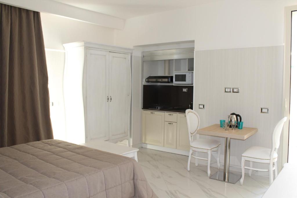 a bedroom with a bed and a table with chairs at Hotel Residence Villa Del Mare in Rimini