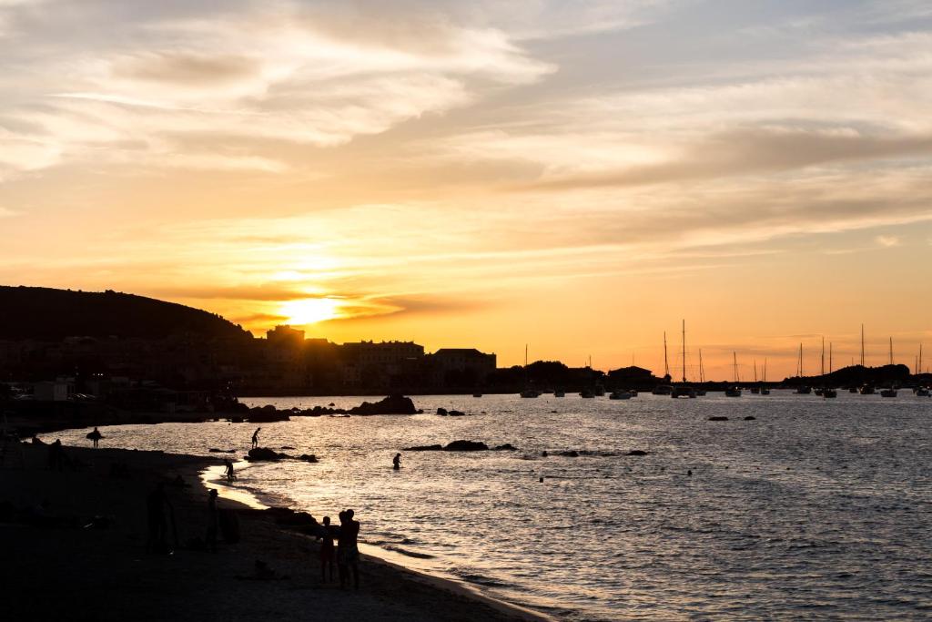 a group of people on the beach at sunset at Joseph Charles in LʼÎle-Rousse