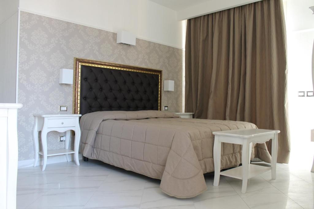 a bedroom with a large bed and two tables at Hotel Residence Villa Del Mare in Rimini