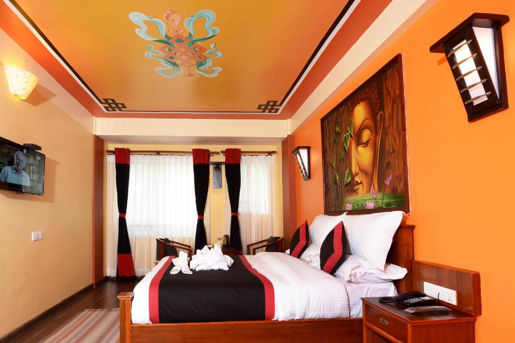 1 dormitorio con 1 cama con paredes de color naranja en Karma Boutique Hotel, en Katmandú