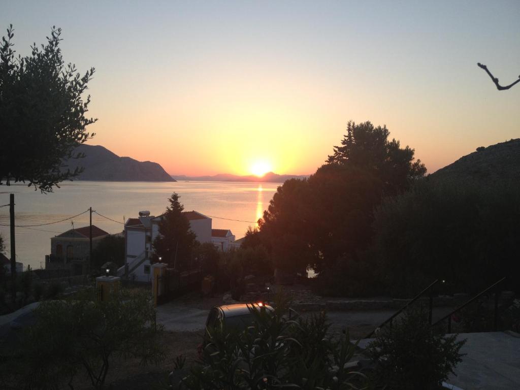 a sunset over a body of water with the sun setting at Panorama Thea in Symi