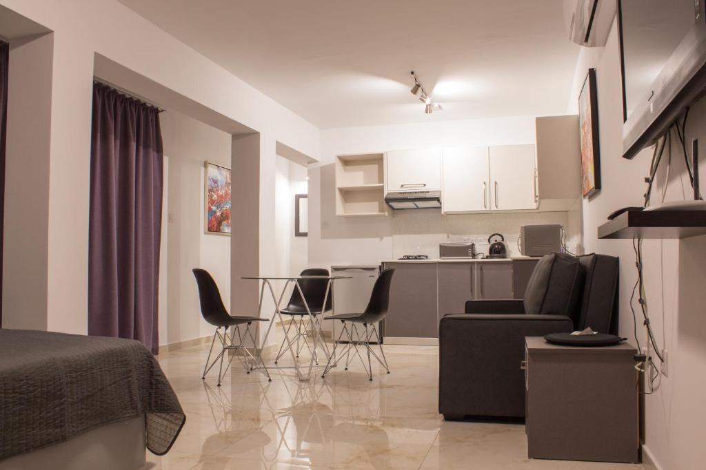 a living room and kitchen with a table and chairs at Makronissos Beach Studio in Ayia Napa