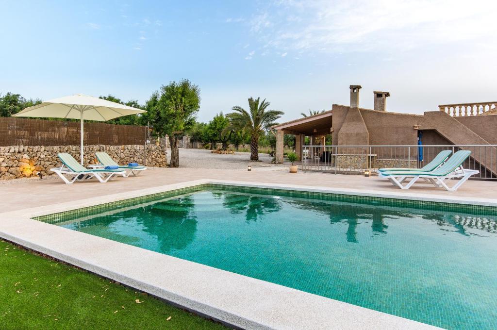 una piscina con 2 sillas y una casa en Son Morro en Santa Margalida