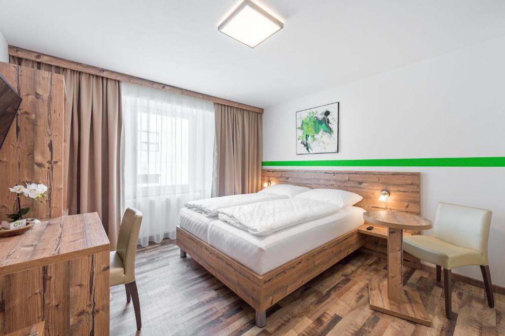 a bedroom with a bed and a desk and a table at City Rooms Wels - contactless check-in in Wels