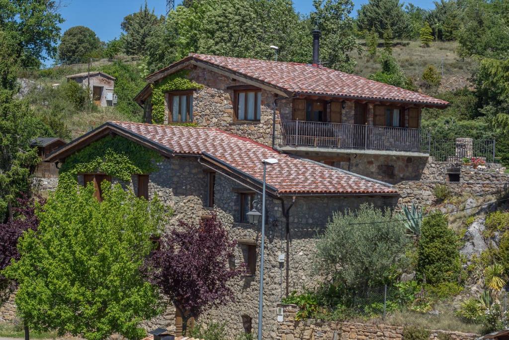 een groot stenen huis op een heuvel met bomen bij Casa Sisquet in Montcortes