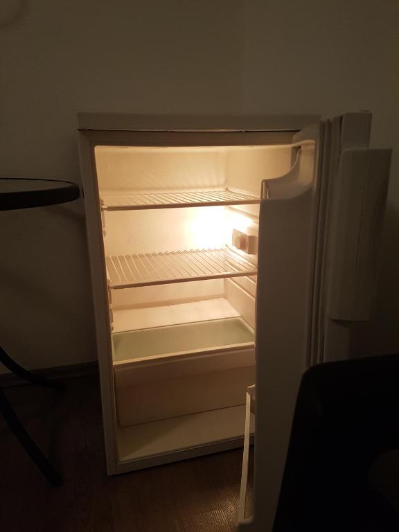 an empty refrigerator with its door open in a room at Guest House Sombrero in Senj