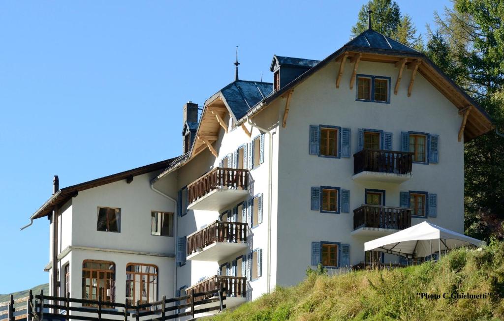 un edificio blanco con balcones en una colina en Hotel de la Sage, en La Sage