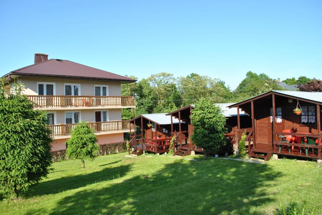 a large house with a yard in front of it at Nad Jeziorem Domki i Pokoje 781-281-434 in Polańczyk