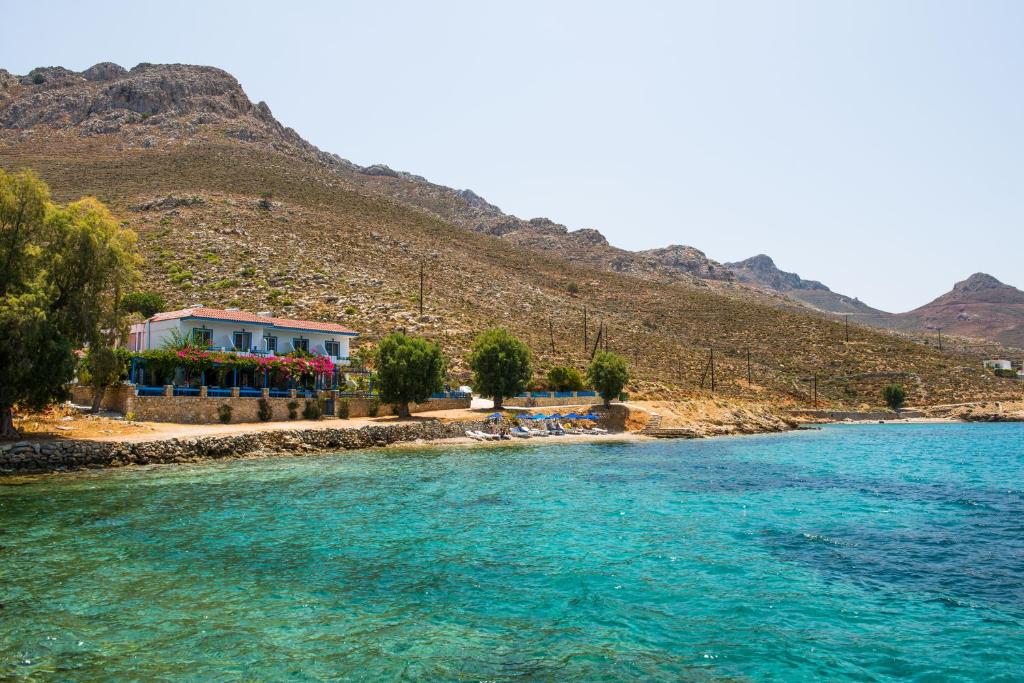 ein Haus am Ufer eines Wasserkörpers in der Unterkunft Faros Rooms in Livadia