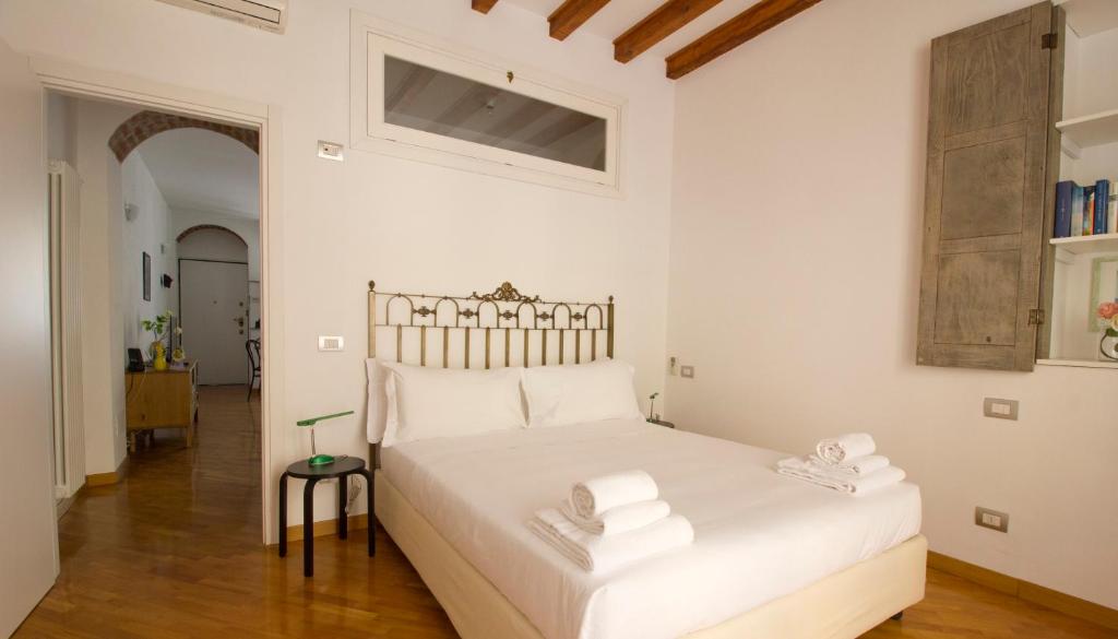 1 dormitorio con 1 cama blanca y 2 toallas en Italianway-Lambro, en Milán