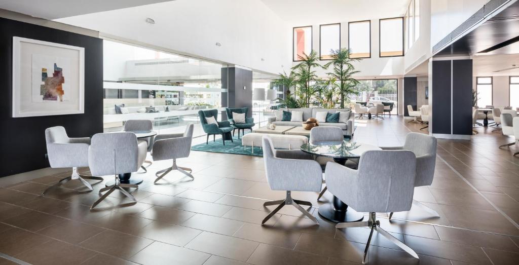 a lobby with a table and chairs and a couch at Ilunion Calas de Conil in Conil de la Frontera