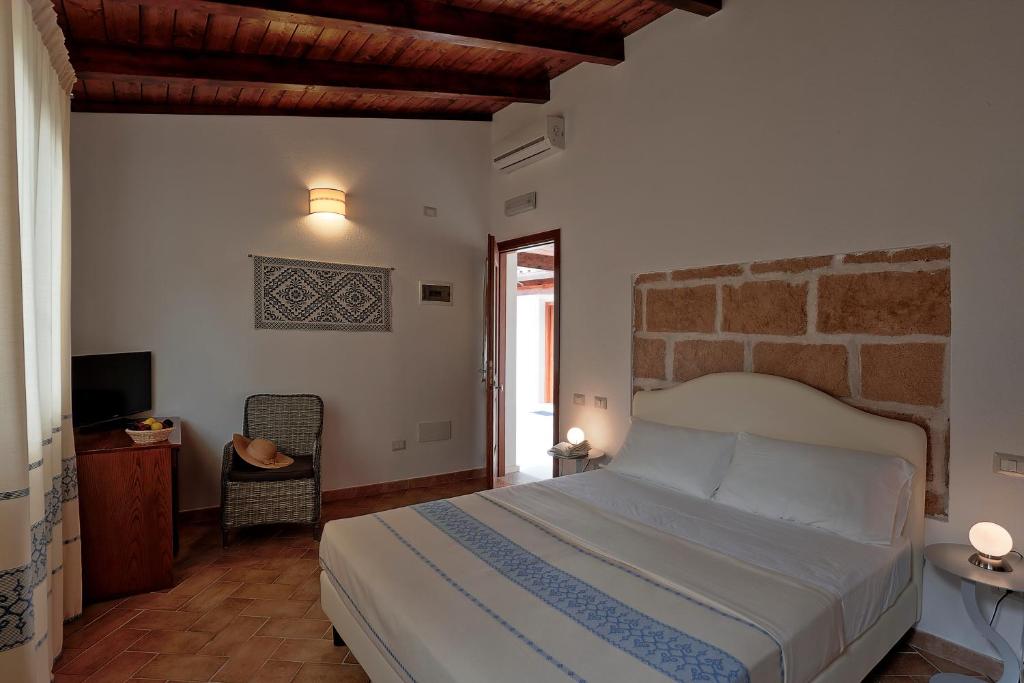 een slaapkamer met een bed en een tv. bij Agriturismo Casale Degli Ulivi Alghero in Santa Maria la Palma