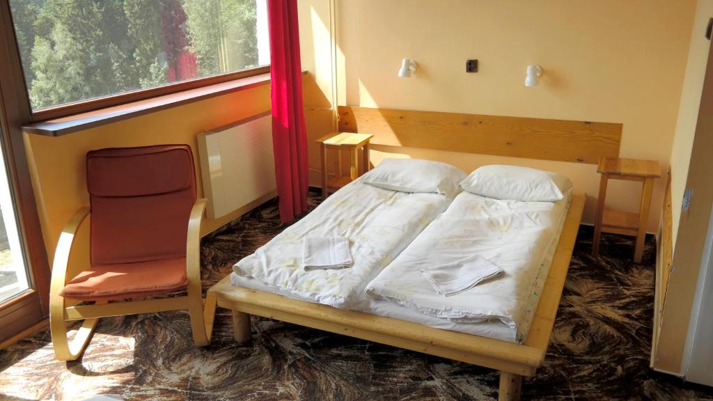 a bedroom with a bed and a chair and a window at Piecuch in Karpacz