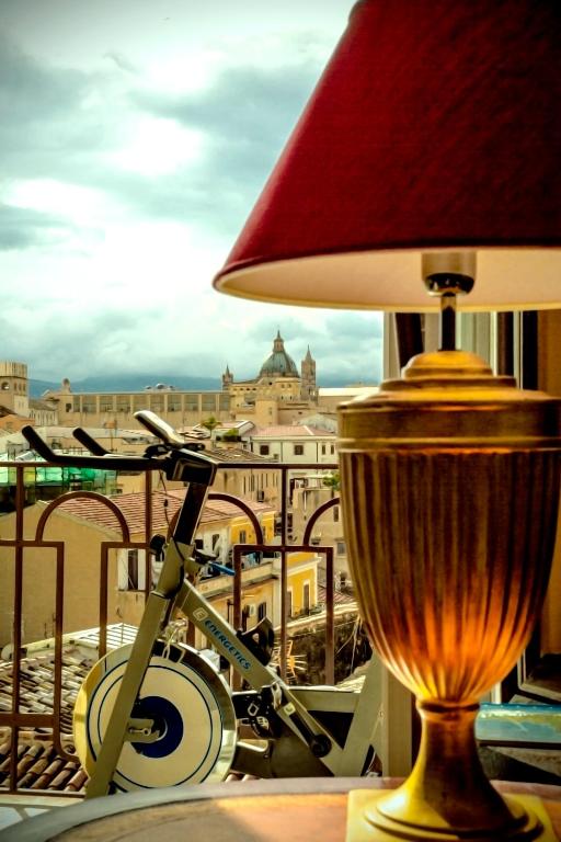 lampa siedząca na stole z widokiem na miasto w obiekcie La Maison del Sole w mieście Palermo