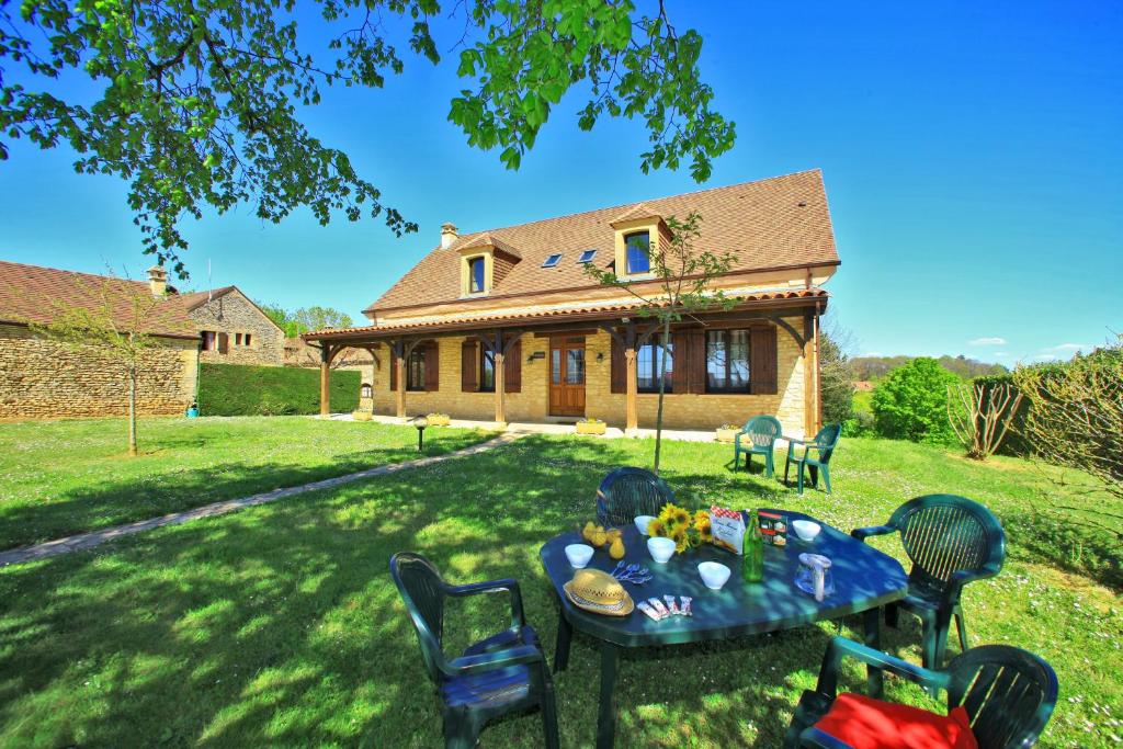 een tafel en stoelen voor een huis bij COMBAS village de gites in Saint-Crépin-et-Carlucet