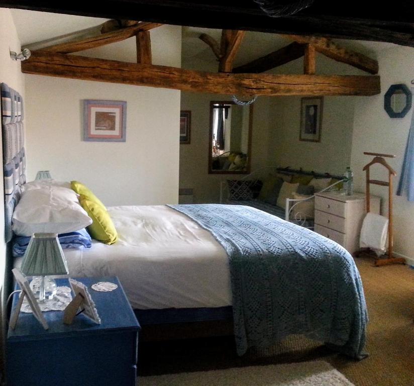 a bedroom with a bed and a table with a lamp at Chambre d'Hôtes Oiron, Deux Sevres - not near Taize, Burgundy in Oiron