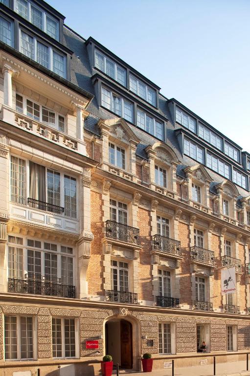 a large brick building with a lot of windows at Villathena in Paris