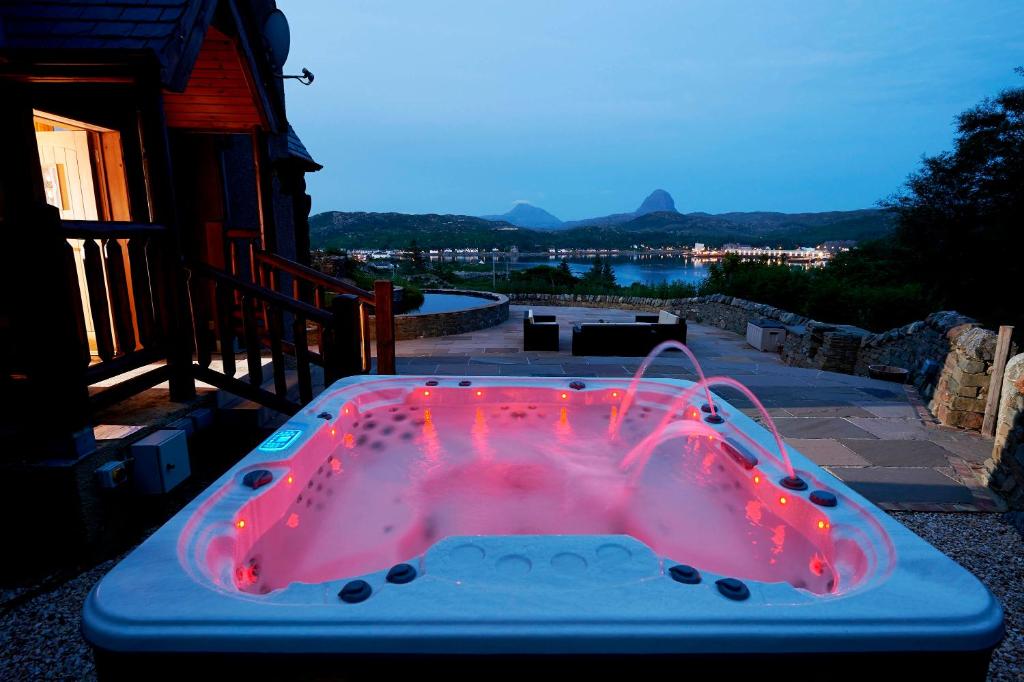 a hot tub with red lights on a patio at Waterloo lodge in Lochinver