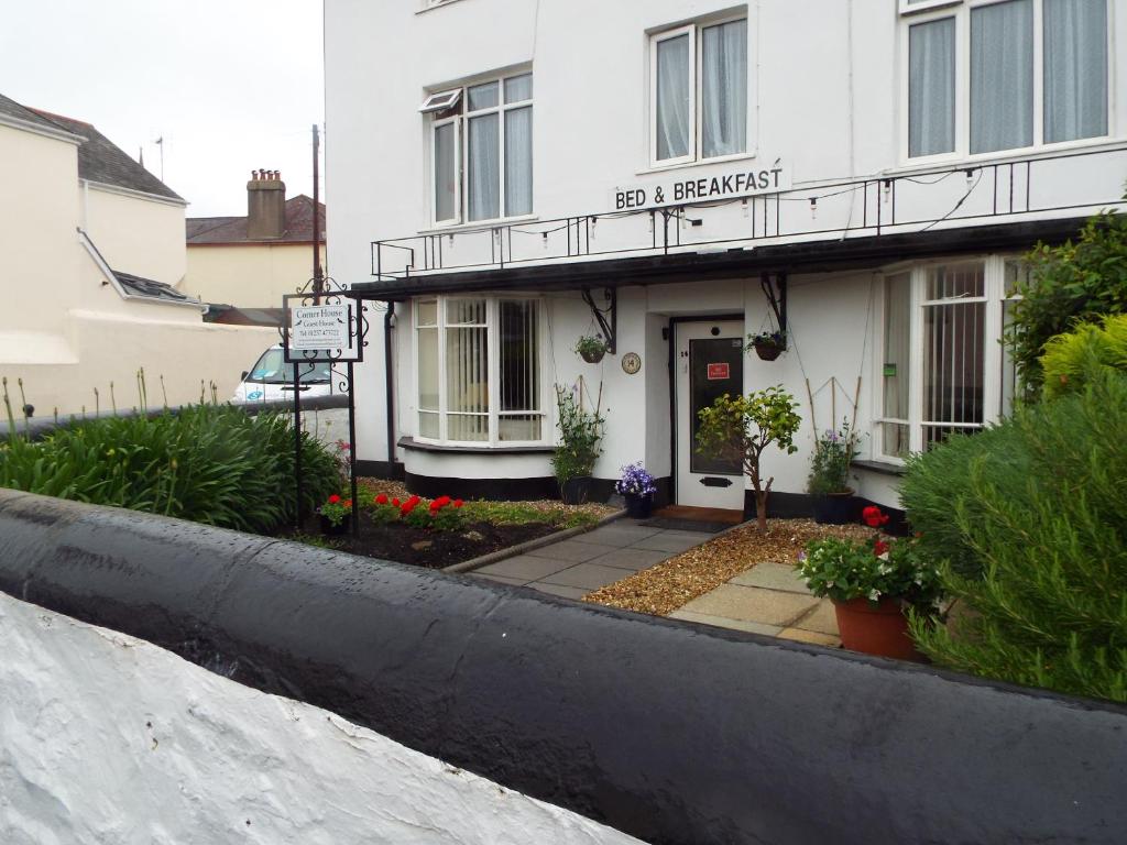 a white building with a sign that reads real breakfast at Corner House Guest House in Bideford