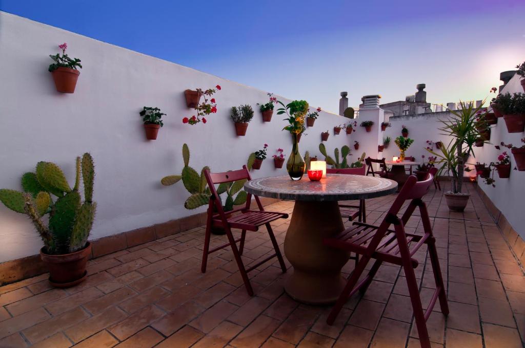 un patio con mesa, sillas y macetas en Un Patio al Sur, en Sevilla