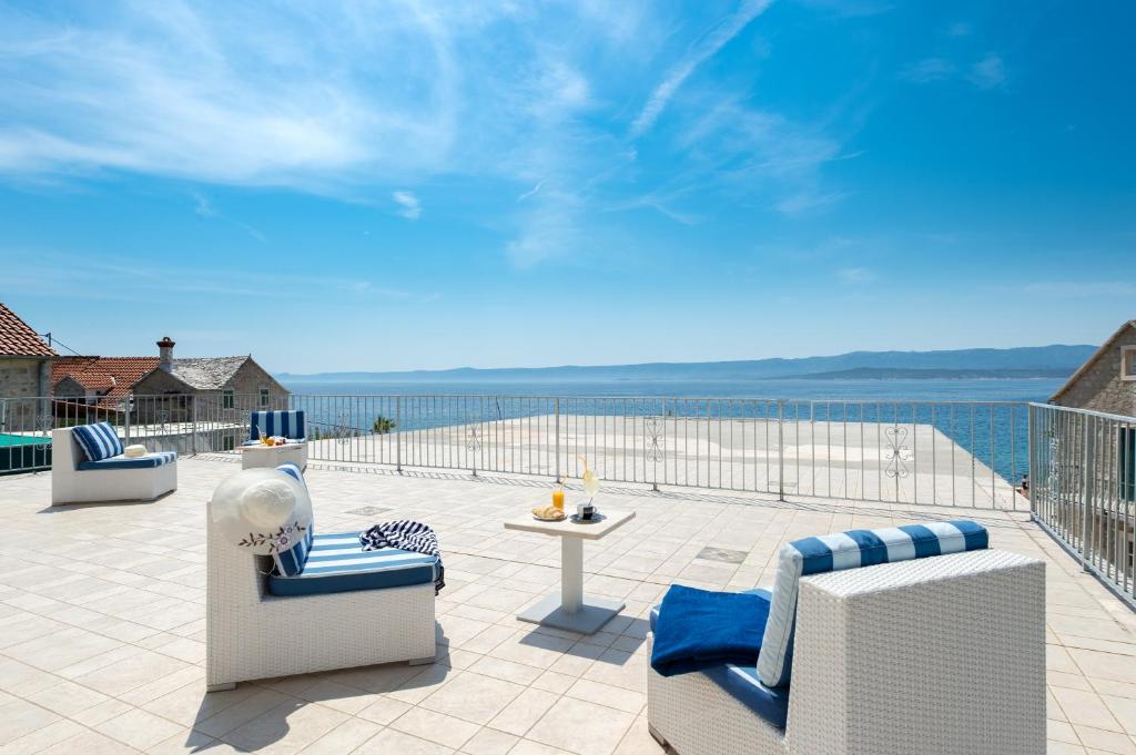 eine Terrasse mit Stühlen und Meerblick in der Unterkunft Riva Rooms in Bol