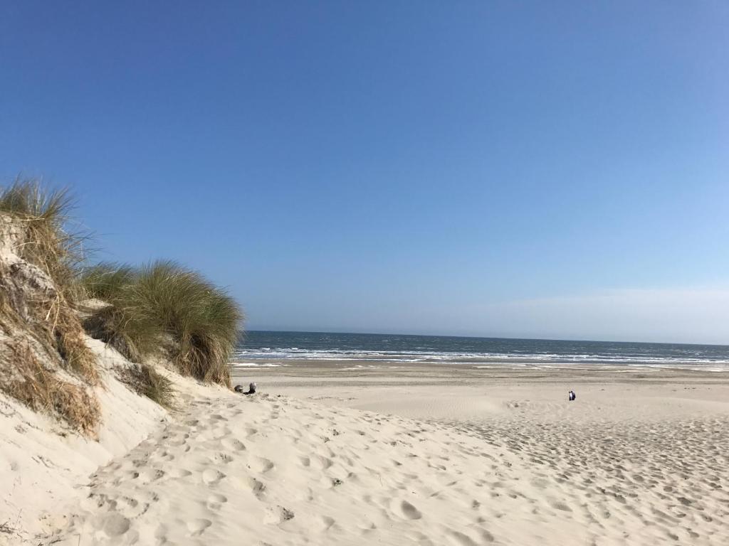 een strand met voetafdrukken in het zand en de oceaan bij Effe Wad in Buren