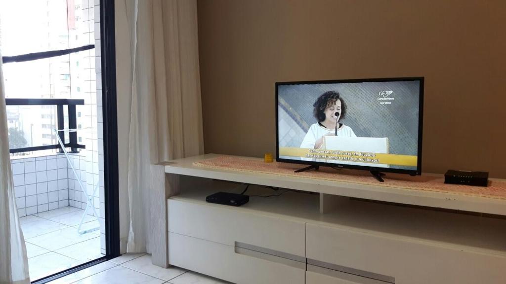 einen Fernseher auf einem Regal im Wohnzimmer in der Unterkunft Apartamento Gorja in Praia Grande