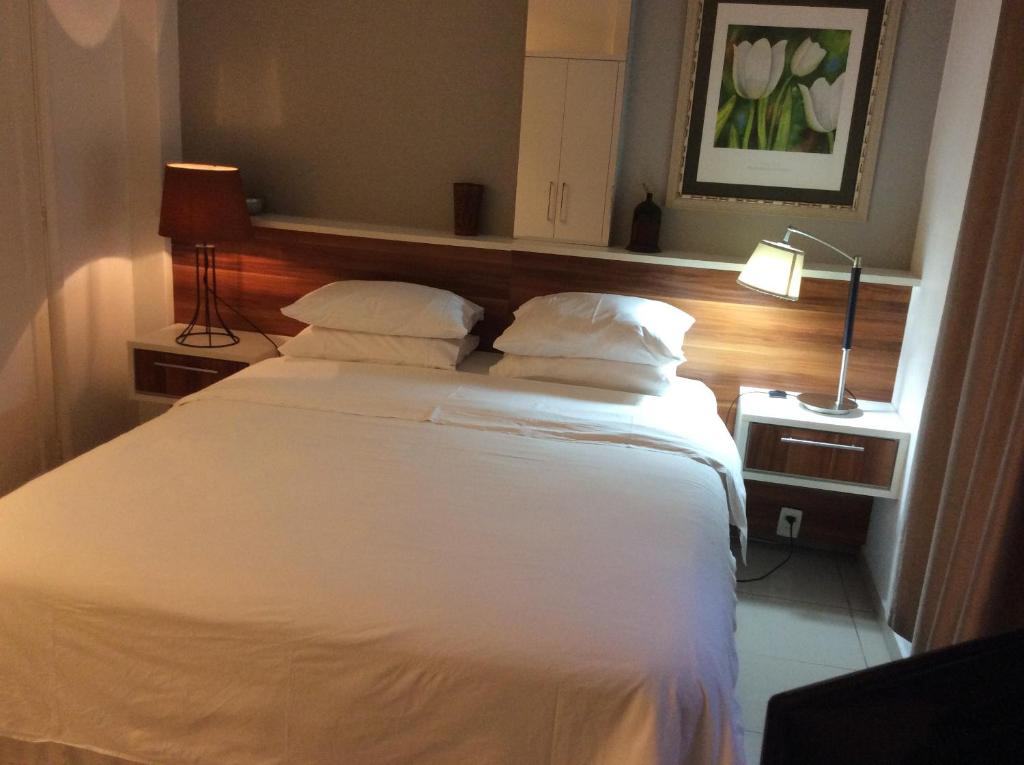 1 dormitorio con 1 cama con sábanas y almohadas blancas en Ipanema Prudente 205, en Río de Janeiro