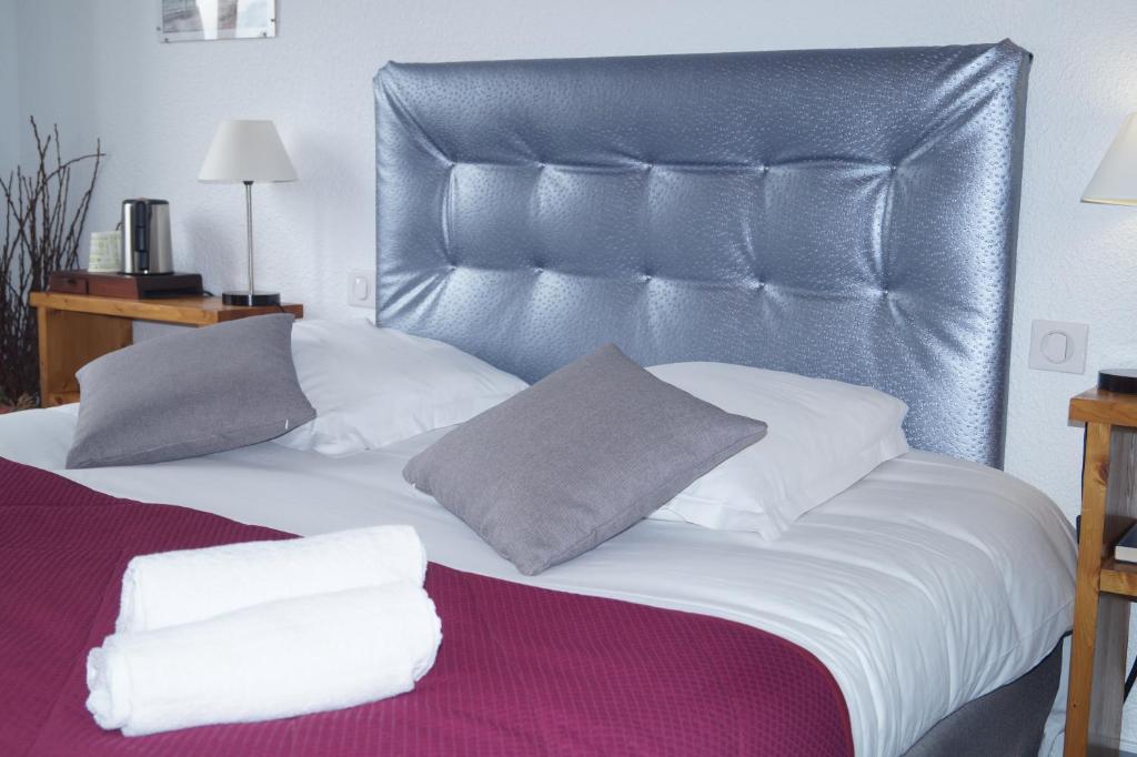 1 cama con cabecero de cuero y almohadas en Le Val d'Amby, en Hières-sur-Amby